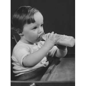  Baby Girl (9 12 Months) Sitting in Highchair, Drinking Milk 